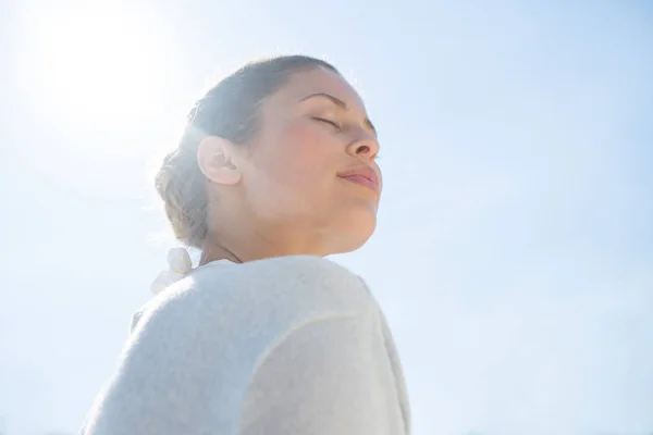 对晴朗的天空闭着眼睛的女人 — 图库照片