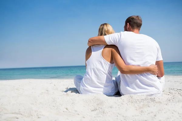 Couple avec bras autour de détente à la plage — Photo