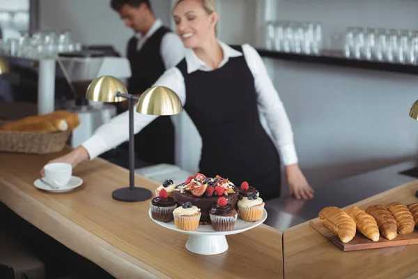 Waitress serving coffee at counter — Stock Photo, Image