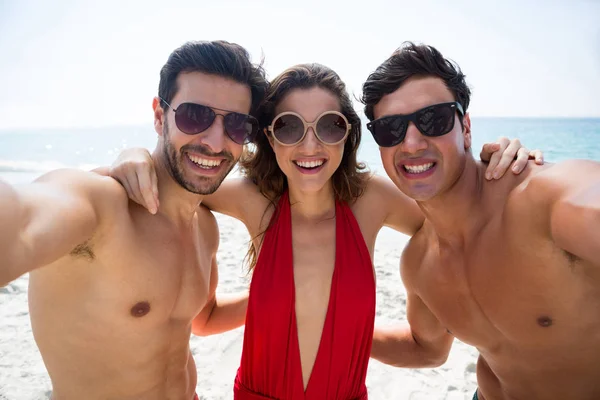 Amici che indossano occhiali da sole in spiaggia — Foto Stock