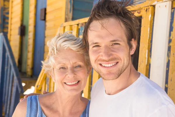 Hombre con madre de pie contra la cabaña de playa — Foto de Stock