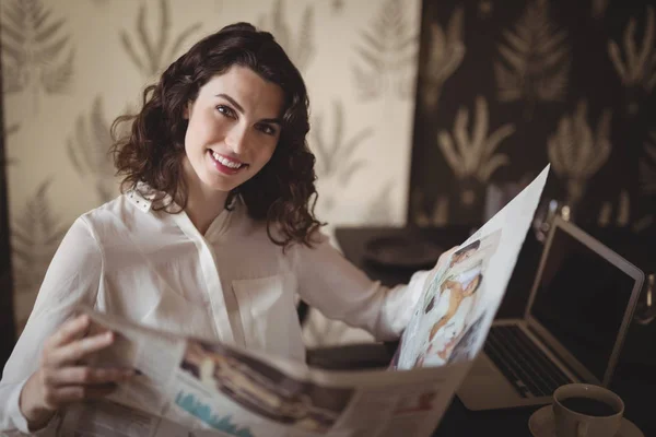 Женщина читает газету в ресторане — стоковое фото