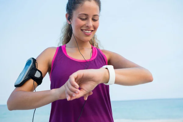 Donna che utilizza orologio intelligente in spiaggia — Foto Stock