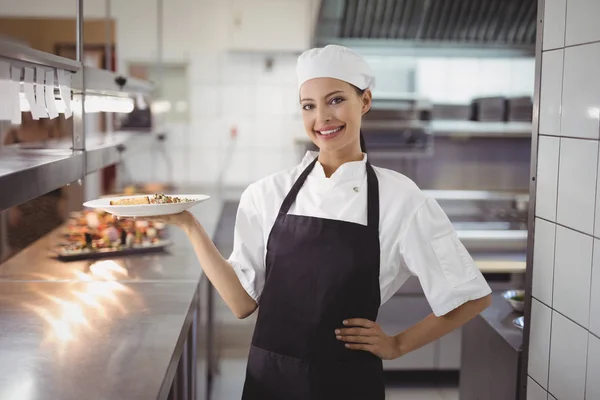 Chef feminino mostrando prato de comida — Fotografia de Stock