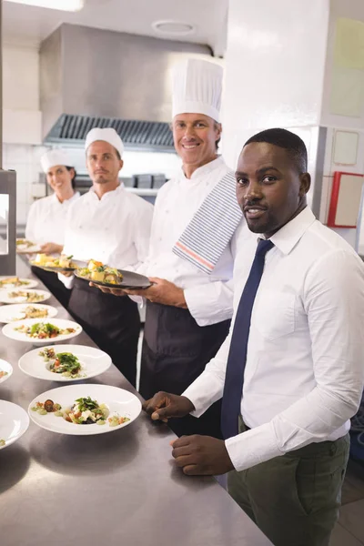 Directeur de restaurant avec son personnel de cuisine — Photo