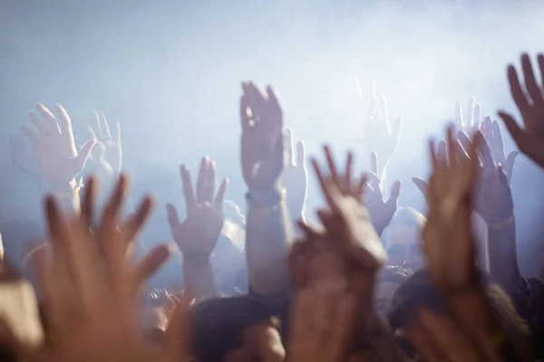 Menigte met armen verhoogd genieten bij nightclub — Stockfoto