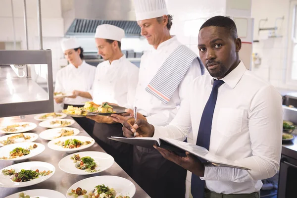 Gerente do restaurante com sua equipe de cozinha — Fotografia de Stock