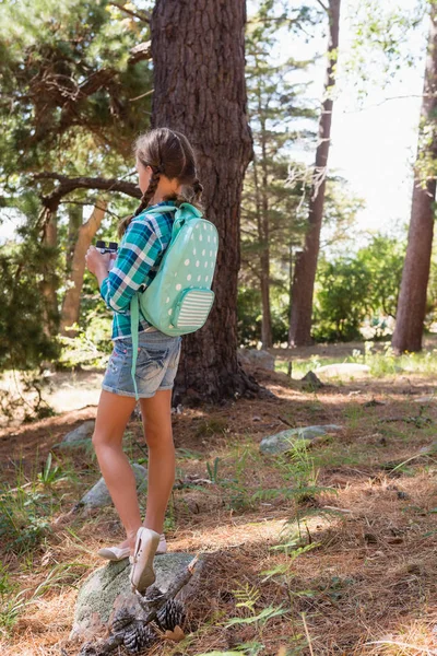 Дівчина стоїть в лісі з біноклями — стокове фото