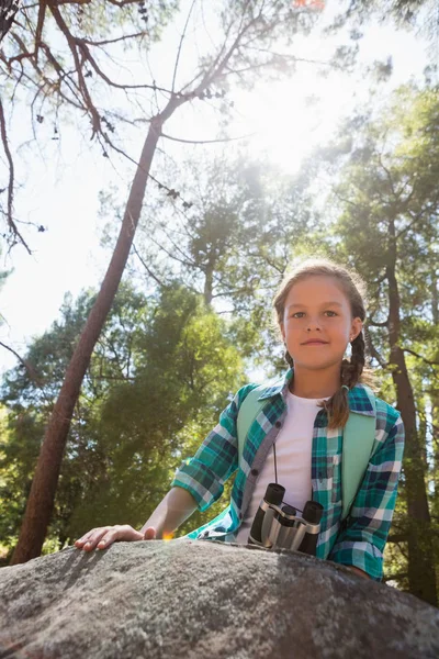 Chica apoyada en la roca en el bosque — Foto de Stock