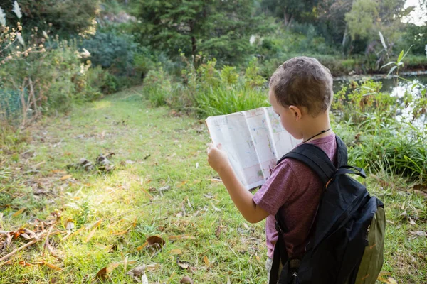Chlapec, čtení mapy v lese — Stock fotografie