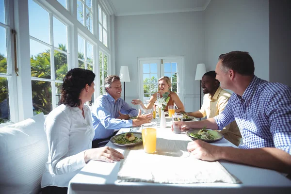 Friends interacting while having meal — Stock Photo, Image