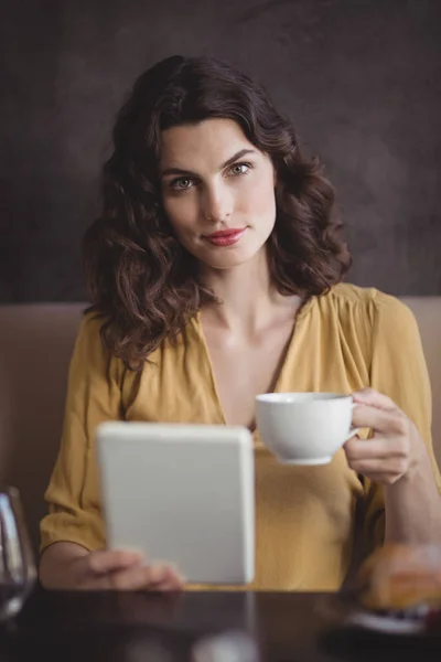 Жінка тримає чашку кави і планшет — стокове фото