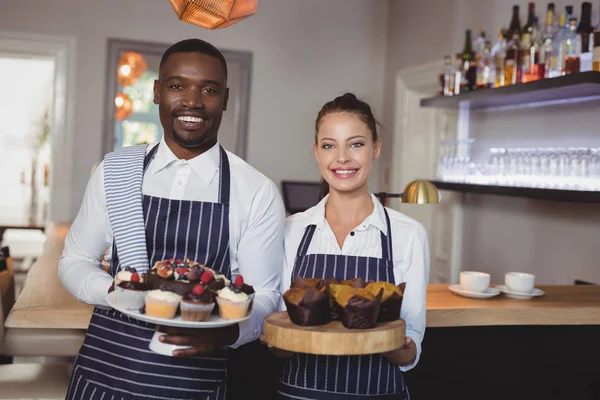 Servitör och servitris hålla desserter — Stockfoto