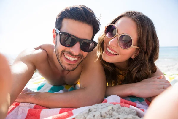 Couple wearing sunglasses while lying together — Stock Photo, Image