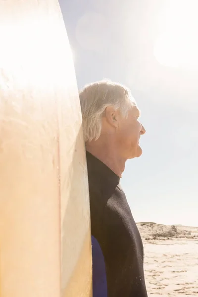 Senior avec planche de surf debout contre le ciel — Photo