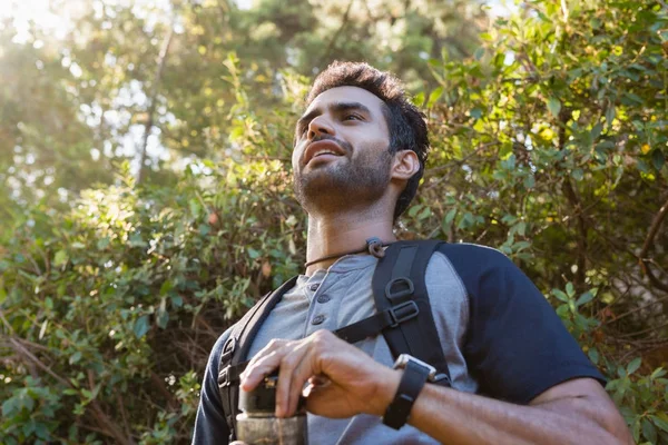 Mannen innehar en vattenflaska i skogen — Stockfoto