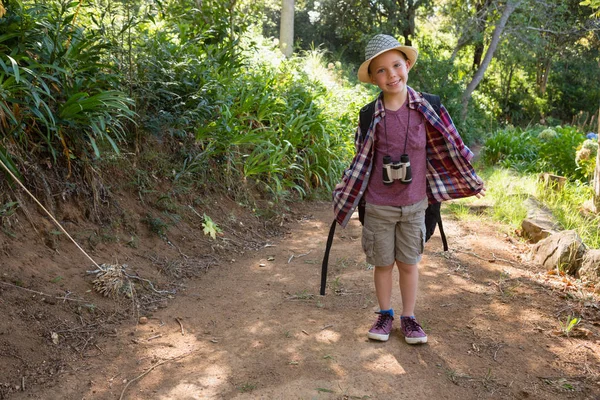 Улыбающийся мальчик стоит в лесу — стоковое фото