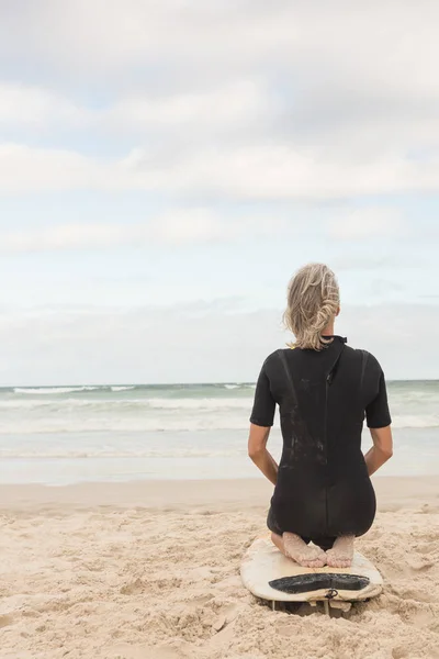 Frau mit Surfbrett am Strand — Stockfoto