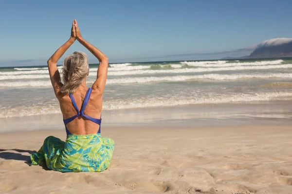 Femme avec les bras levés pratiquant le yoga — Photo