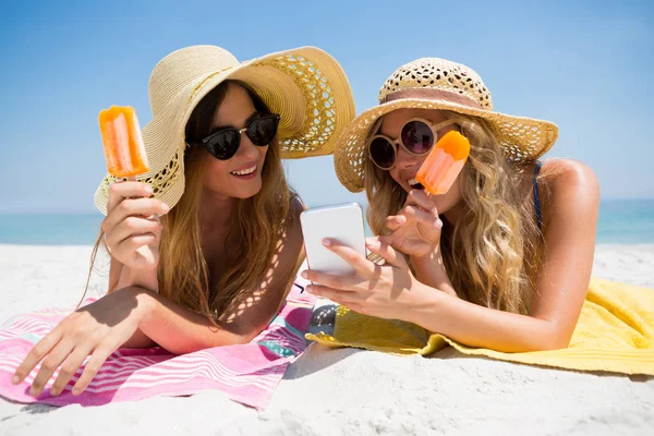 Freunde nutzen Smartphone beim Eis am Stiel — Stockfoto