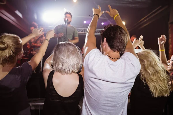 Fans genieten van met armen verhoogd bij nightclub — Stockfoto