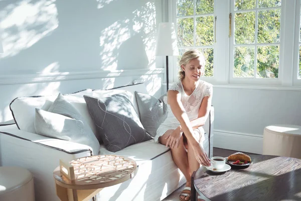 Femme prenant un café sur canapé — Photo