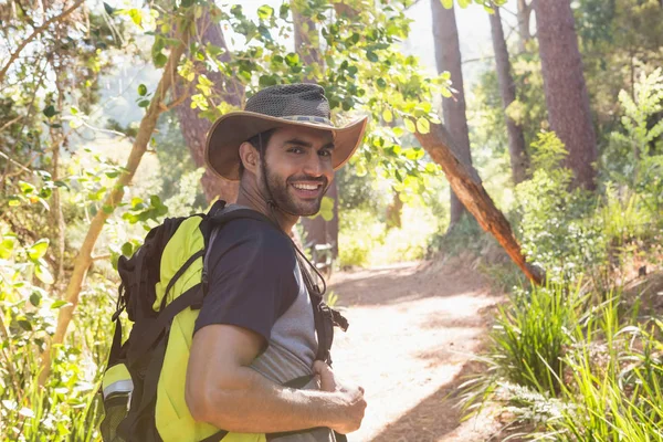 Man met rugzak lopen op wandelpad in bos — Stockfoto