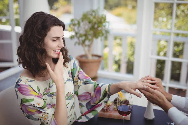 Uomo mettendo anello di fidanzamento sulla mano della donna — Foto Stock