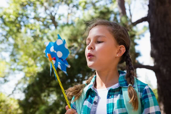 Girl blowing a pinwheel — Stock Photo, Image