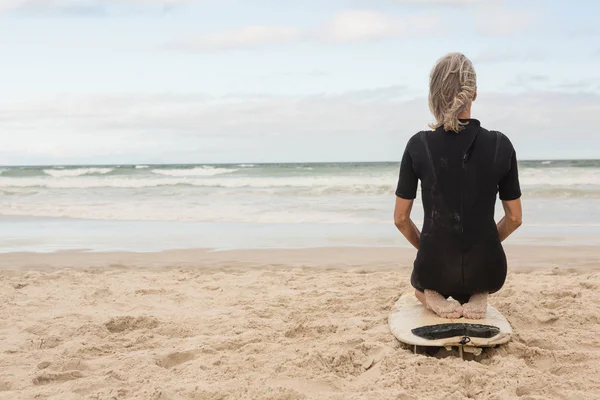 Frau mit Surfbrett am Strand — Stockfoto