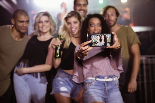 Femme gaie prenant selfie avec des amis — Photo