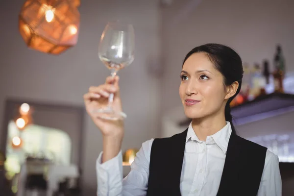 Kelnerka, patrząc na pusty kieliszek do wina — Zdjęcie stockowe