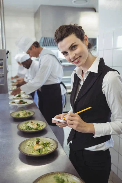 Kellnerin mit Notizblock in der Küche — Stockfoto