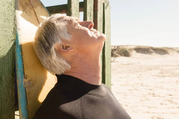 Homme âgé debout près de la planche de surf — Photo