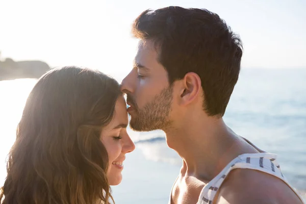 Uomo baciare fidanzata fronte a spiaggia — Foto Stock