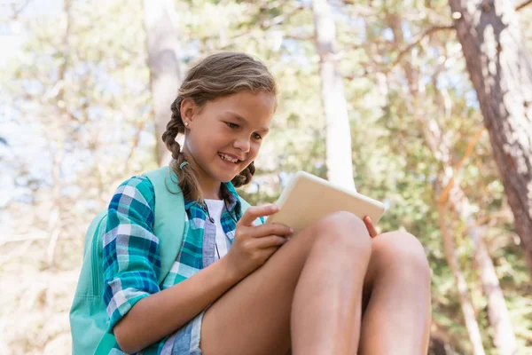 Chica usando una tableta digital en el bosque —  Fotos de Stock