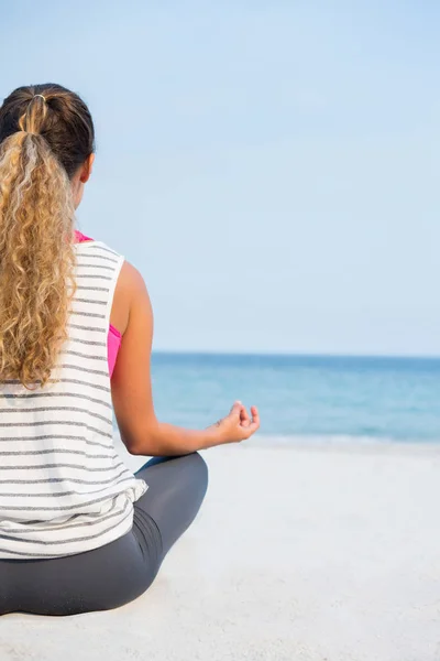 Vrouw praktizerende yoga op het strand — Stockfoto