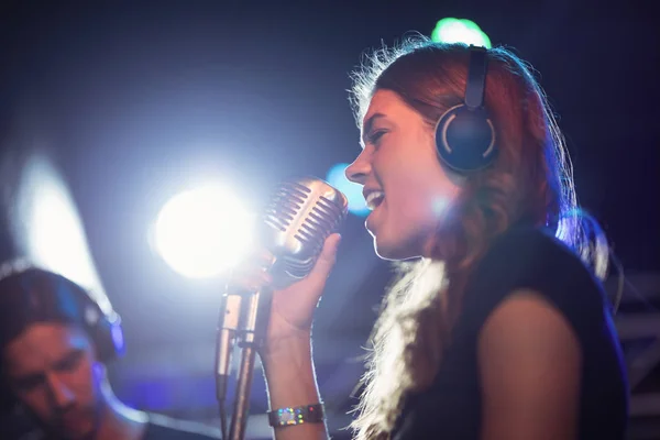 Female singer wearing headphones — Stock Photo, Image