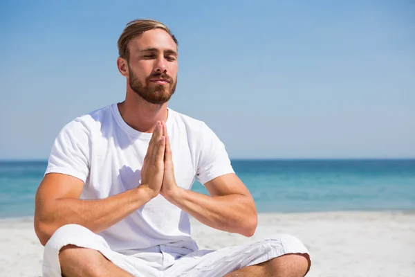 Hombre en posición de oración haciendo ejercicio en la playa — Foto de Stock