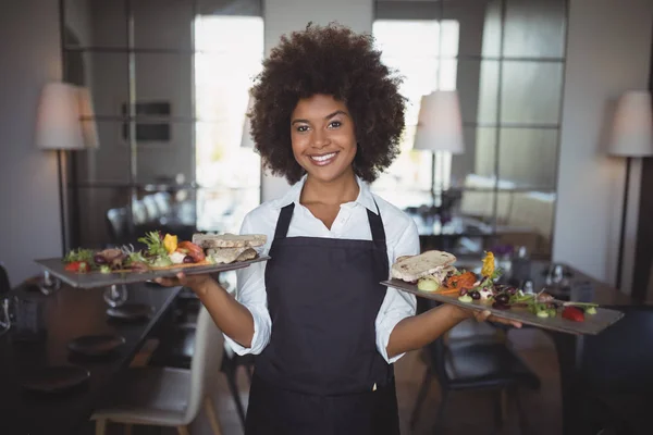 Camarera sonriente sosteniendo bandeja de comida — Foto de Stock