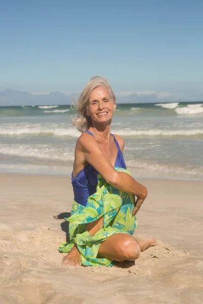 모래에 앉아있는 동안 요가 연습 하는 여자 — 스톡 사진