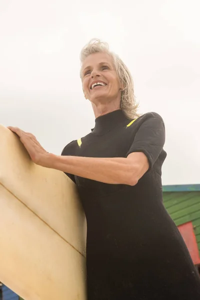 Donna allegra che trasporta tavola da surf — Foto Stock