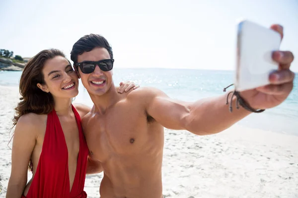 Ungt par med selfie på stranden — Stockfoto