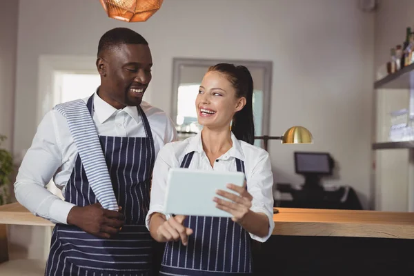 Waiter and waitress discussing over digital tablet — Stock Photo, Image