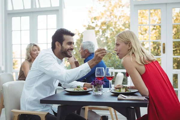 Чоловік годує жінку в ресторані — стокове фото