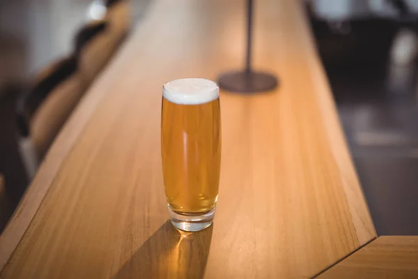A glass of beer at counter — Stock Photo, Image