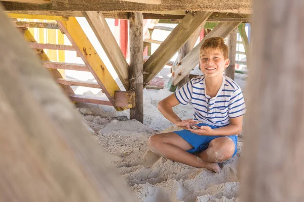 Sorridente ragazzo che gioca con la sabbia — Foto Stock