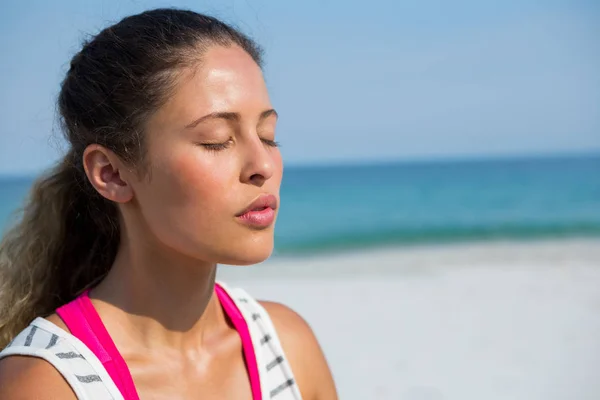 Mujer con los ojos cerrados meditando en la playa —  Fotos de Stock