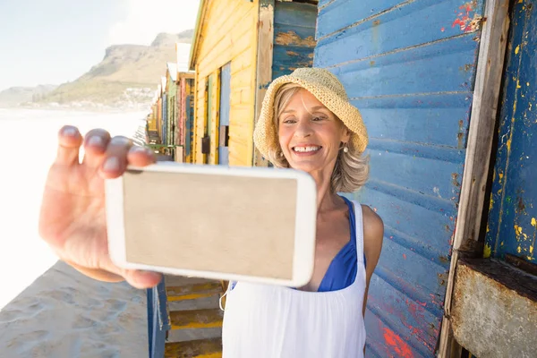Усміхнена жінка тримає телефон — стокове фото