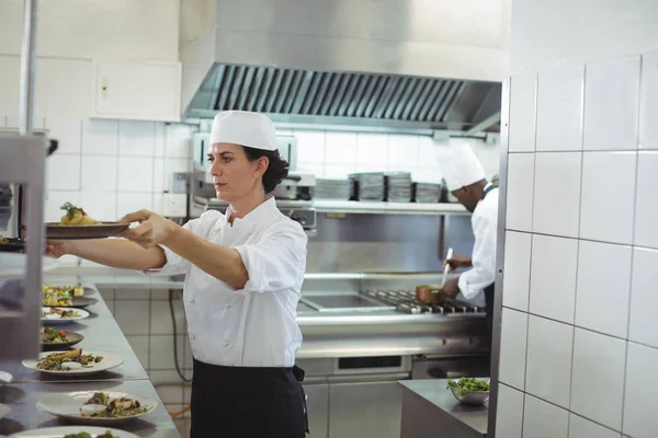 Vrouwelijke chef-kok houden voorgerecht plaat — Stockfoto